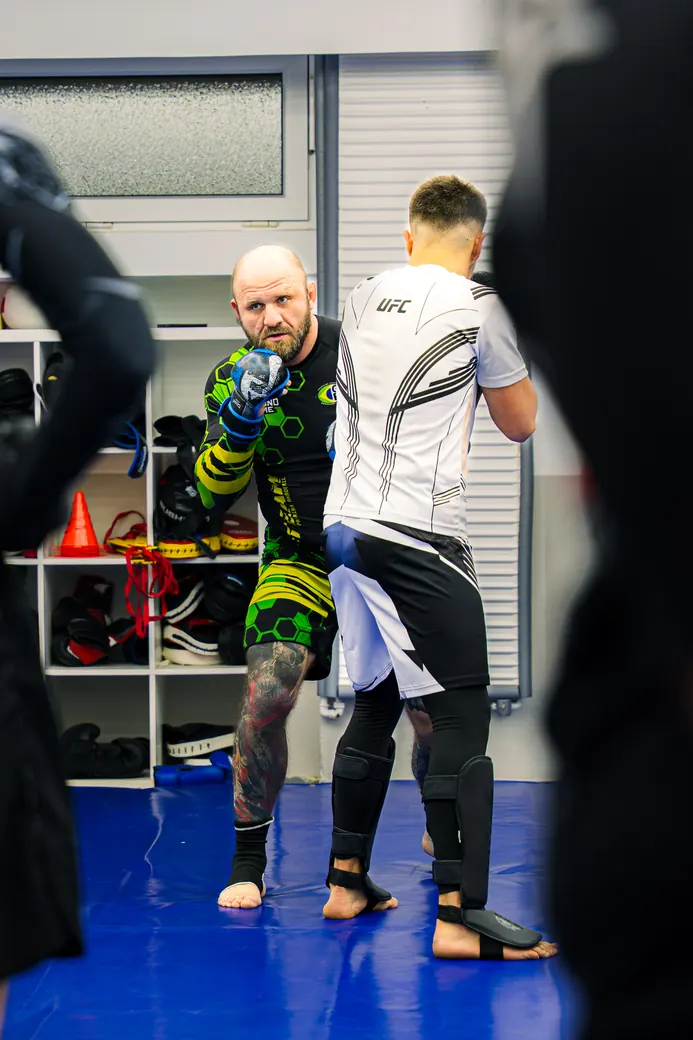 MMA-Training: Trainer mit Schüler auf der Matte